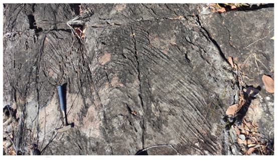 A hammer and a hammer on a rock
Description automatically generated